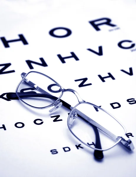 Óculos na carta de teste — Fotografia de Stock