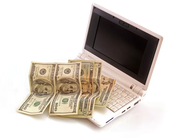 Koncepcja z dolarów i laptop biały na białym tle — Zdjęcie stockowe