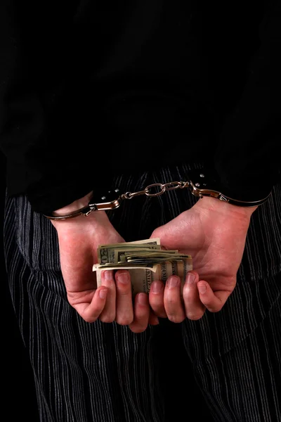 Чоловік з наручниками і доларами на чорному — стокове фото