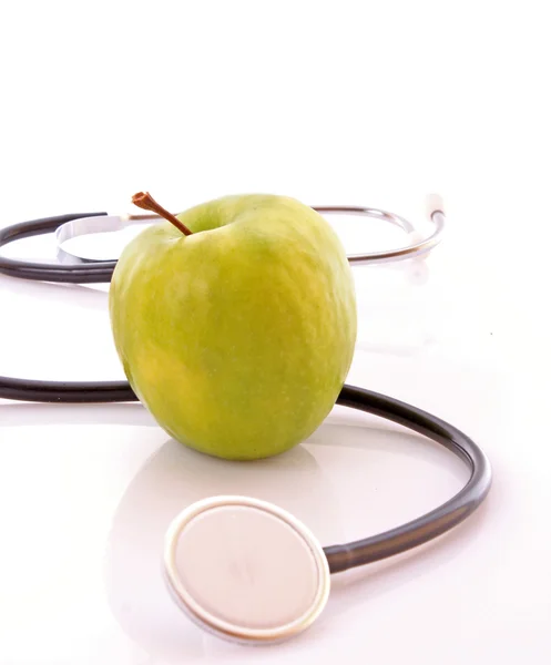 Stethoskop und grüner Apfel lizenzfreie Stockfotos