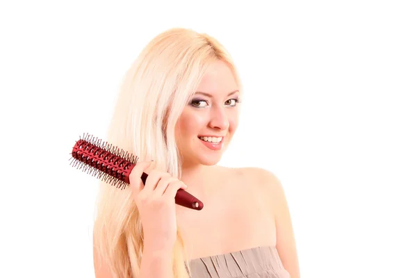 Mooie jonge blonde vrouw haar lange haren borstelen — Stockfoto