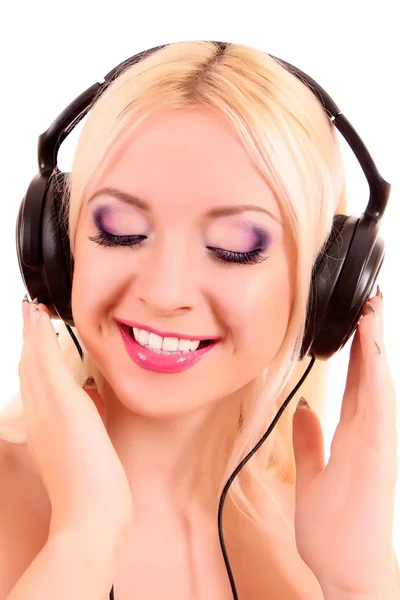 Vackra unga blonda kvinnan med ljusa make-up lyssnar musik — Stockfoto