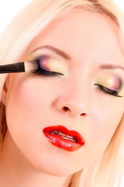 Mooie jonge blonde vrouw met lichte make-up en borstel op w — Stockfoto