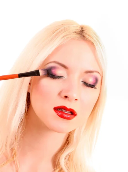Hermosa joven rubia con maquillaje brillante y cepillo en wh —  Fotos de Stock