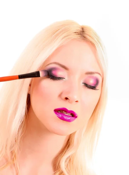 Hermosa joven rubia con maquillaje brillante y cepillo en wh — Foto de Stock