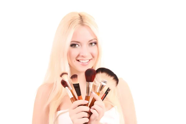 Beautiful young blonde woman with bright make-up and many brushe — Stock Photo, Image