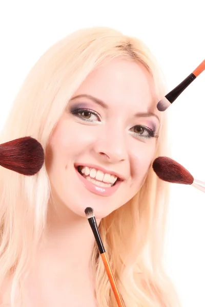 Beautiful young blonde woman with bright make-up and many brushe — Stock Photo, Image