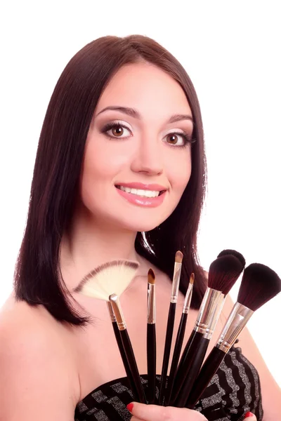 Mulher bonita com pincéis de maquiagem perto de rosto atraente — Fotografia de Stock