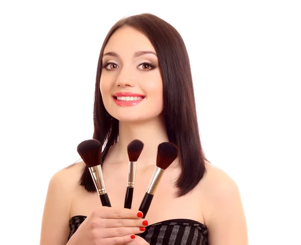Beautiful young woman with make-up brushes near attractive face — Stock Photo, Image