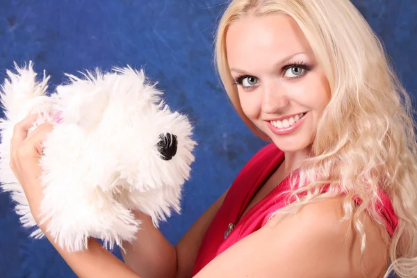 Красивая блондинка в розовом платье с маленькой собачкой на голубом — стоковое фото