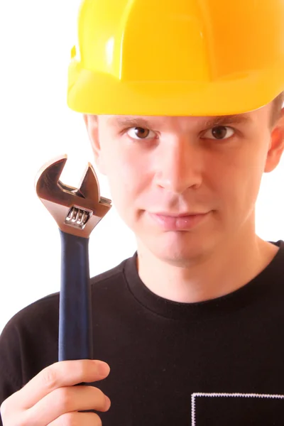Handsome young men in a yellow building helmet and spanner in — Stock Photo, Image
