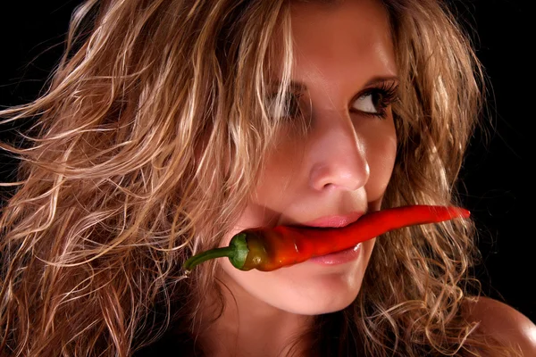 Portrait of beautiful sexy woman with hot chili pepper on black — Stock Photo, Image