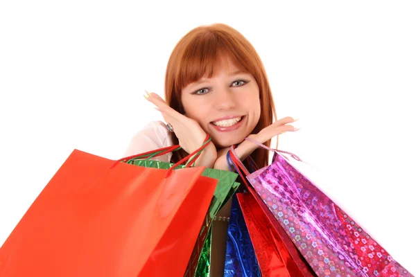 Mulher ruiva bonita, jovem, com sacos de compras coloridos em seu — Fotografia de Stock
