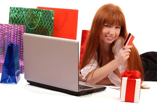 Rothaarige Frau mit farbigen Einkaufstüten kauft im Internet ein — Stockfoto