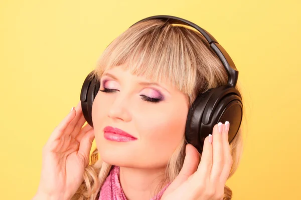 Beautiful young women listening music in headphones — Stock Photo, Image