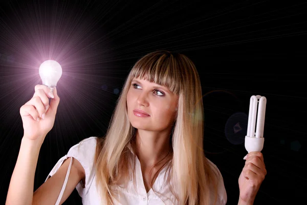 stock image Bright incandescent bulb in young woman hands on black backgroun