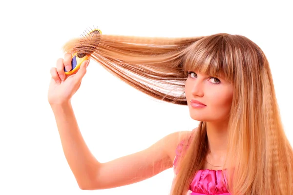 Beautiful young girl combing hair — Stock Photo, Image