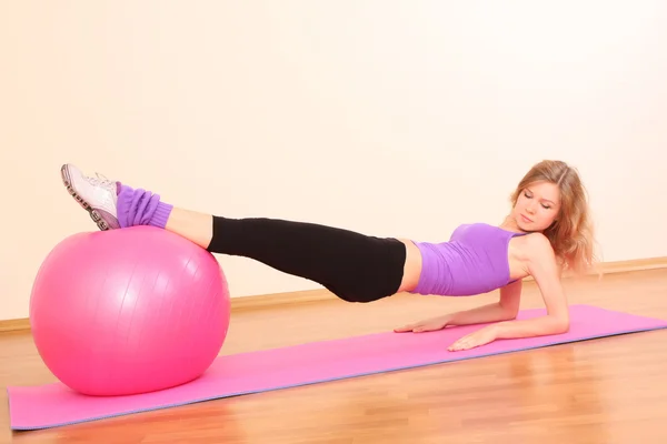 Young beautiful fitness girl with pink ball exercising in the g — Stock Photo, Image