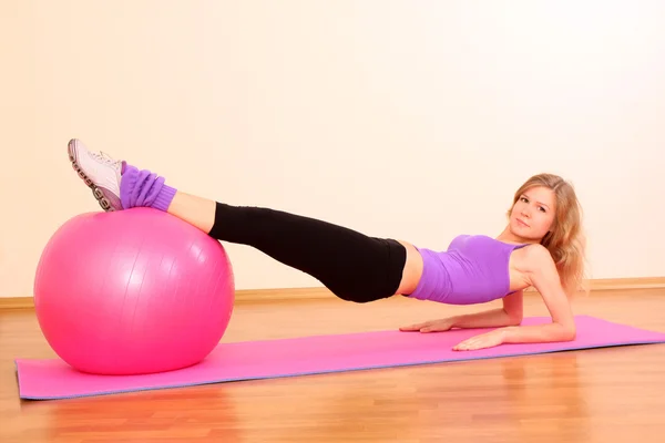 Молодая красивая девушка фитнес с розовым мячом упражнения в г — стоковое фото