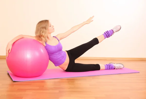 Giovane bella ragazza fitness con palla rosa esercizio nel g — Foto Stock