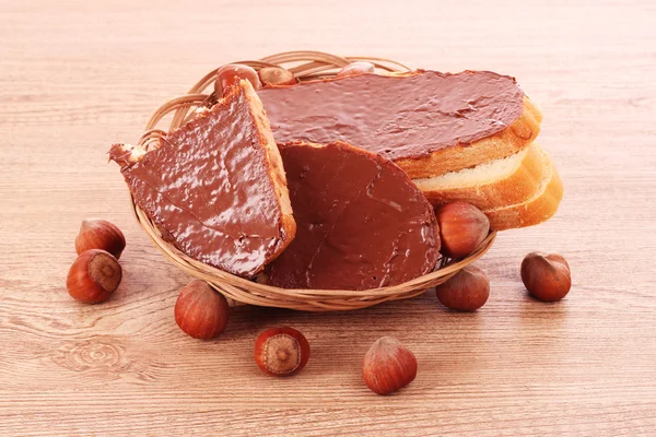 Brood, koekjes en noten met chocolade op houten tafel — Stockfoto