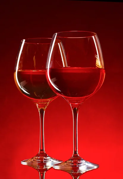 Бокалы для вина на красном фоне — стоковое фото