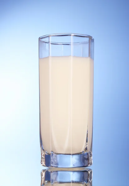 Glas met melk op blauwe achtergrond — Stockfoto