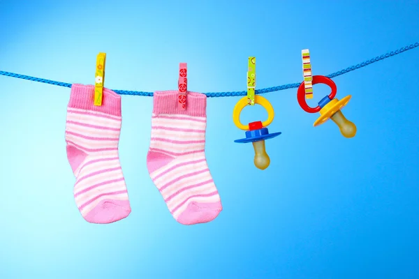 stock image Baby booties and nipple on a blue background