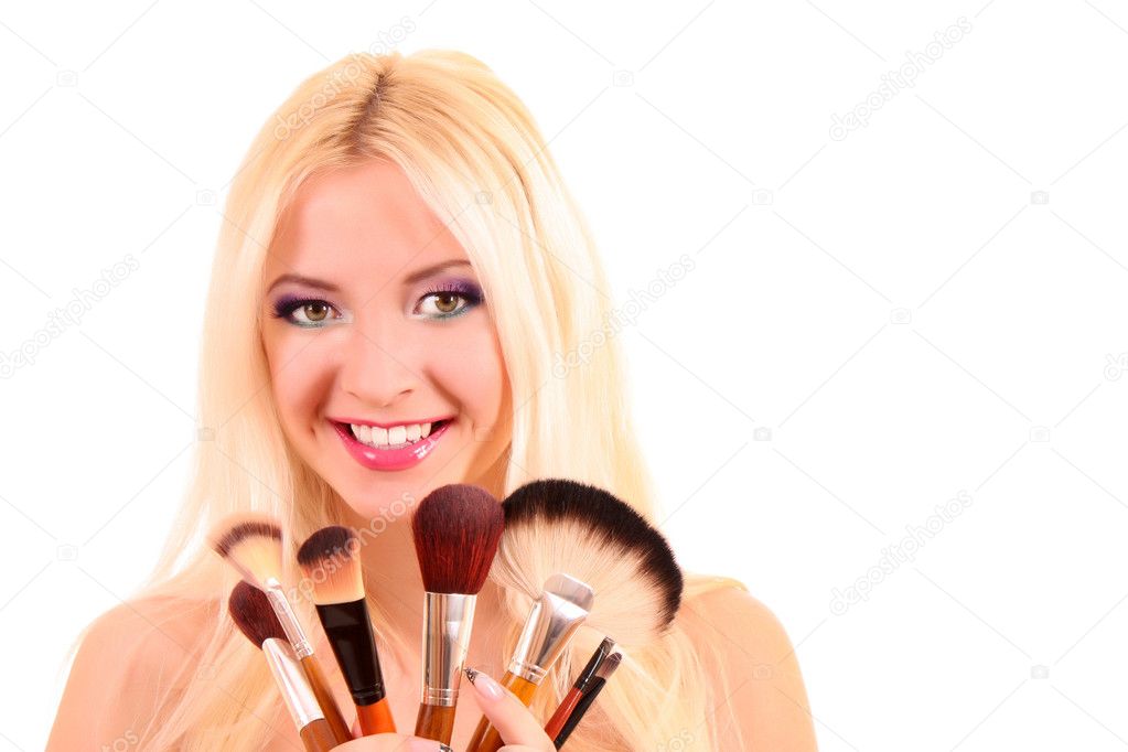 Beautiful young blonde woman with bright make-up and many brushe