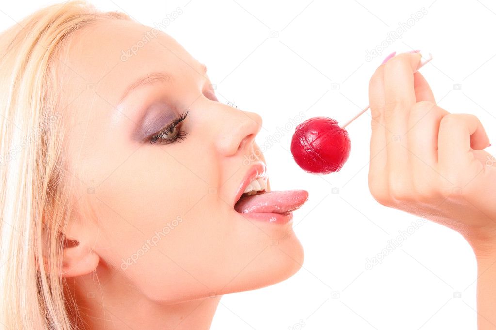 Woman licking sweet sugar candy closeup. Isolated on white.