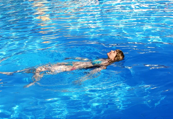 Bela menina nada na piscina — Fotografia de Stock