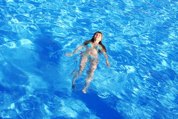 Bela menina nada na piscina — Fotografia de Stock