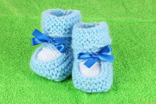 Blue baby booties on green background — Stock Photo, Image
