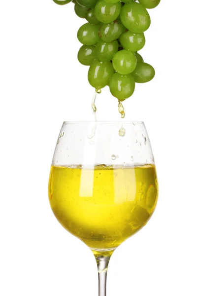 White wine pouring into glass and grapes — Stock Photo, Image