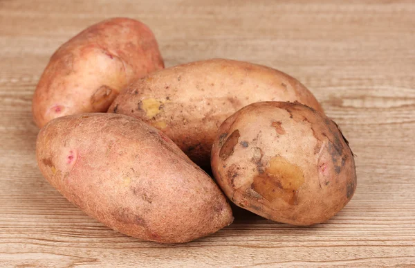 Aardappelen op houten achtergrond — Stockfoto