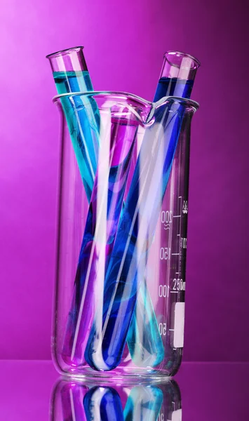 Reagenzgläser auf violettem Hintergrund — Stockfoto
