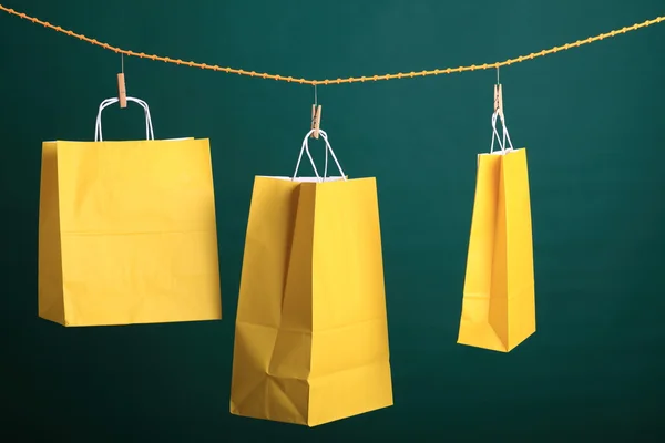 购物在绿色背景上的黄色礼品袋 — 图库照片