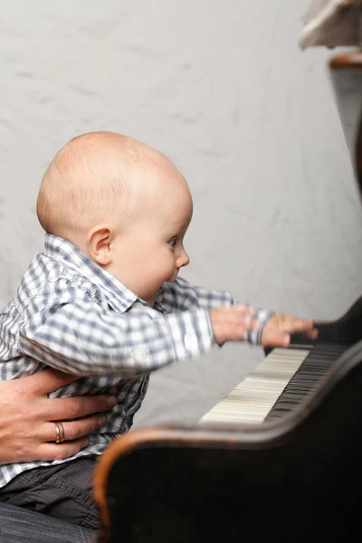 Menino pequeno bonito toca piano — Fotografia de Stock