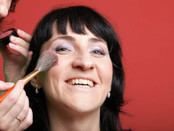 Woman paints face with makeup — Stock Photo, Image
