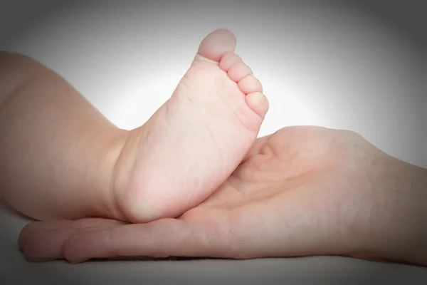 Baby voet in moeder handen — Stockfoto