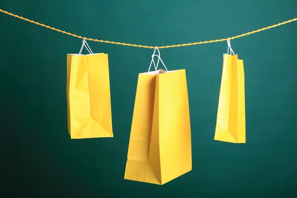 Compras bolsas de regalo amarillas sobre fondo verde —  Fotos de Stock