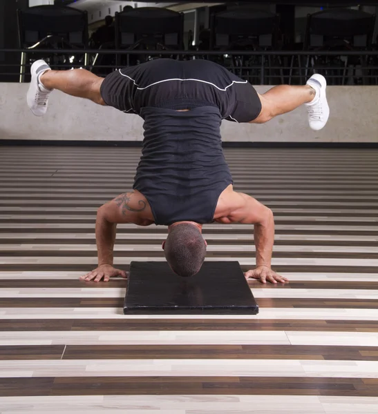 Fitness instructor doing stand on his head — Stock Photo, Image