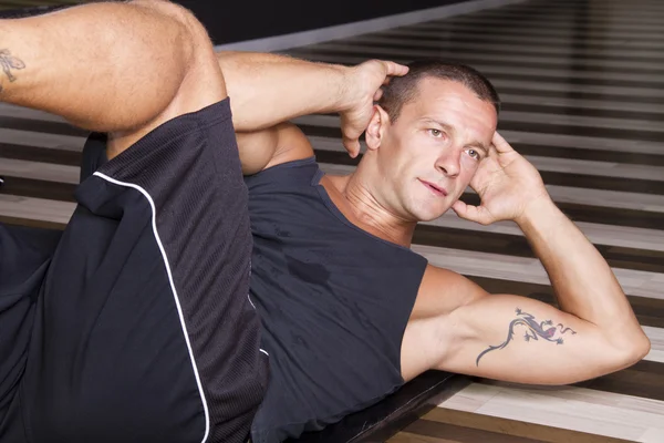 Instrutor de fitness fazendo sit-ups Imagens De Bancos De Imagens