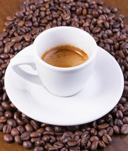 Hot espresso on coffee beans — Stock Photo, Image