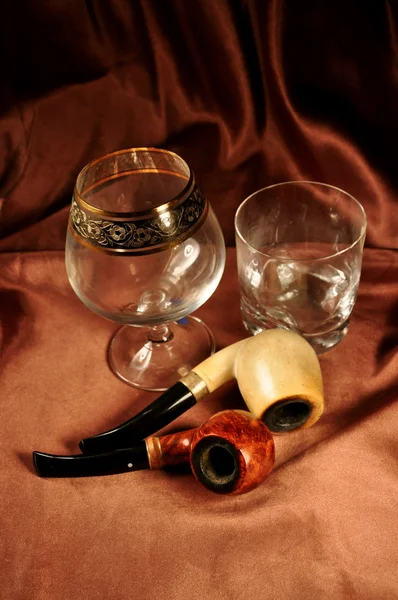Glasses for alcoholic drinks and tobacco pipes — Stock Photo, Image