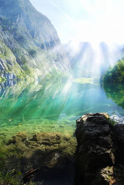 Alpské jezero s paprsky slunce — Stock fotografie
