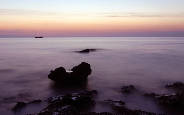 Boot und Felsen bei Sonnenaufgang — Stockfoto