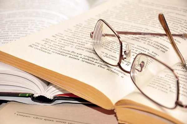 Brille auf offenen Büchern Stockbild