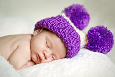 Cute newborn baby sleeps in a hat clipart