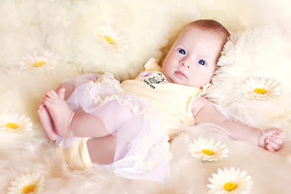 Söt baby ligger i blommor — Stockfoto